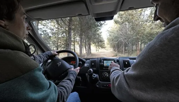 Imagen de dos adultos conduciendo la camper y viendo las vistas del campo 