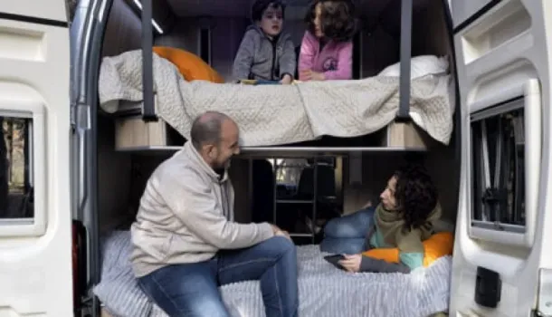 Imagen de dos camas dobles dentro de la camper con familia dentro descansando