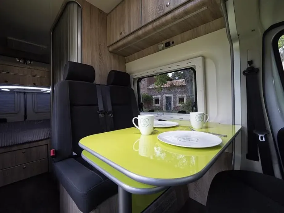 Imagen de furgoneta camperizada por dentro con mesa 