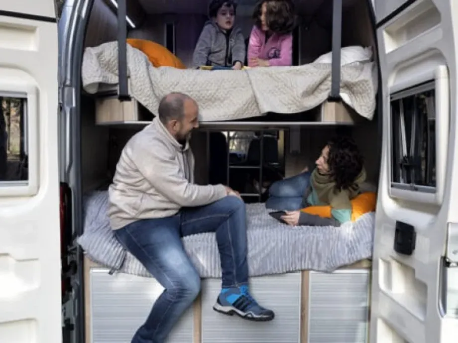 Imagen de una familia dentro de una furgoneta camperizada 