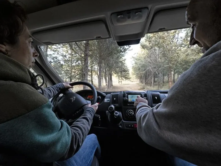 Imagen de dos adultos conduciendo la furgoneta camperizada 