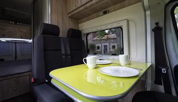 Imagen de interior de camper con desayuno sobre la mesa 