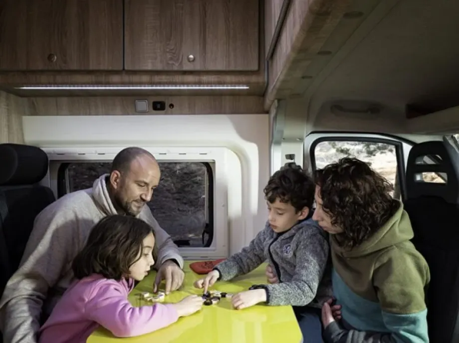 Imagen de una familia dentro de una autocaravana jugando con los niños 