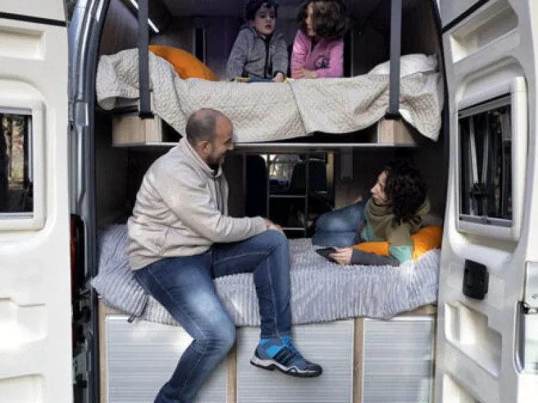 Imagen de una familia dentro de una furgoneta camperizada 